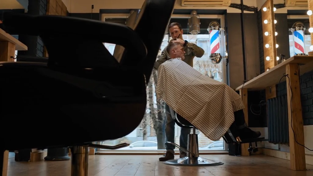 A barber with a client in the chair