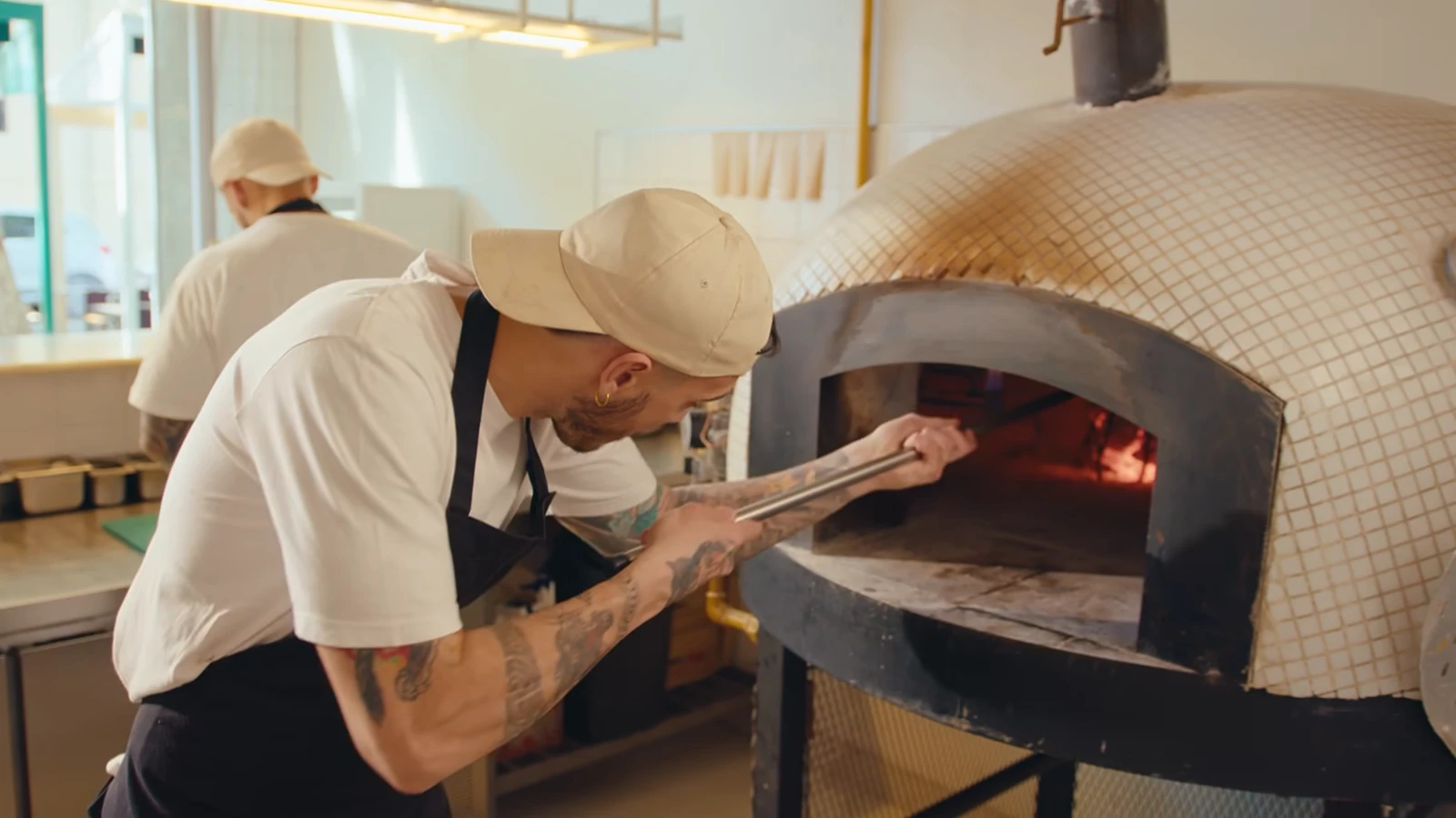 A baker working a wood-fired oven